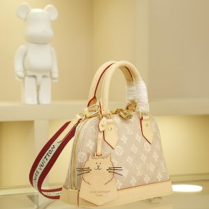 Alternative view of This Alma BB handbag from the Travels With Grace Coddington collection, a collaboration between Louis Vuitton and Grace Coddington, features the playful Meowgram pattern. The canvas body is accented with calf leather trim, while the fabric shoulder strap displays "Louis Vuitton" in Coddington's handwriting. The refined padlock and key pouch further showcase the brand's exceptional craftsmanship.17.5 x 11.5 x 23.5 cm (Height x Width x Length)